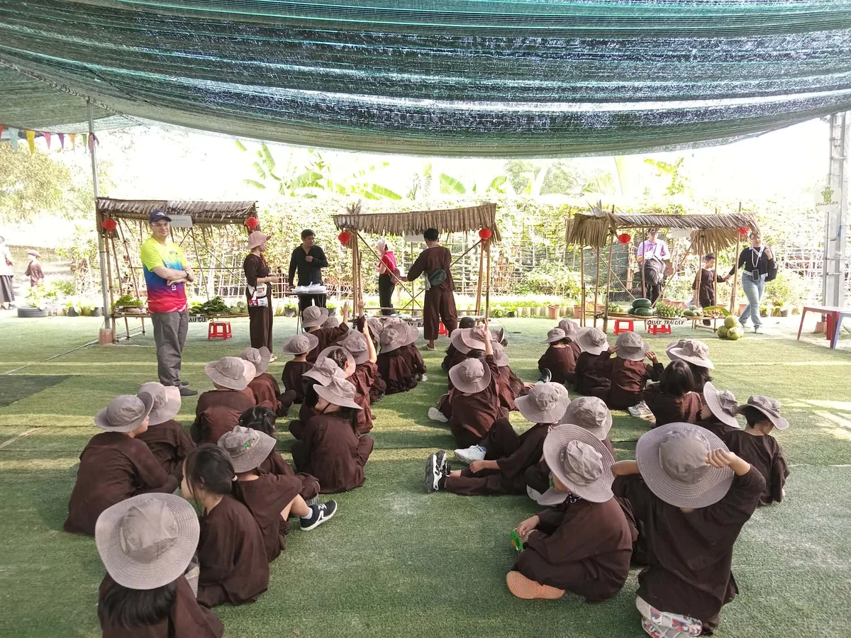 MC nông trại hướng dẫn học sinh trước các gian hàng chợ quê mộc mạc