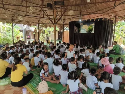 Đoàn học sinh tiểu học xem biểu diễn múa rối cạn dân gian trong nhà sàn gỗ tại Dragon Farm