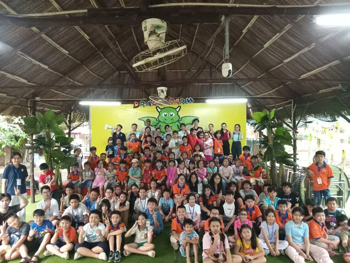 Đoàn học sinh dã ngoại chụp hình tập thể tại sân nhà sàn lá Dragon Farm