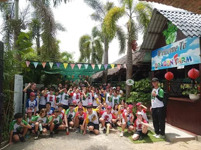 Học sinh trường quốc tế đa quốc tịch check-in trước cổng Welcome to Dragon Farm
