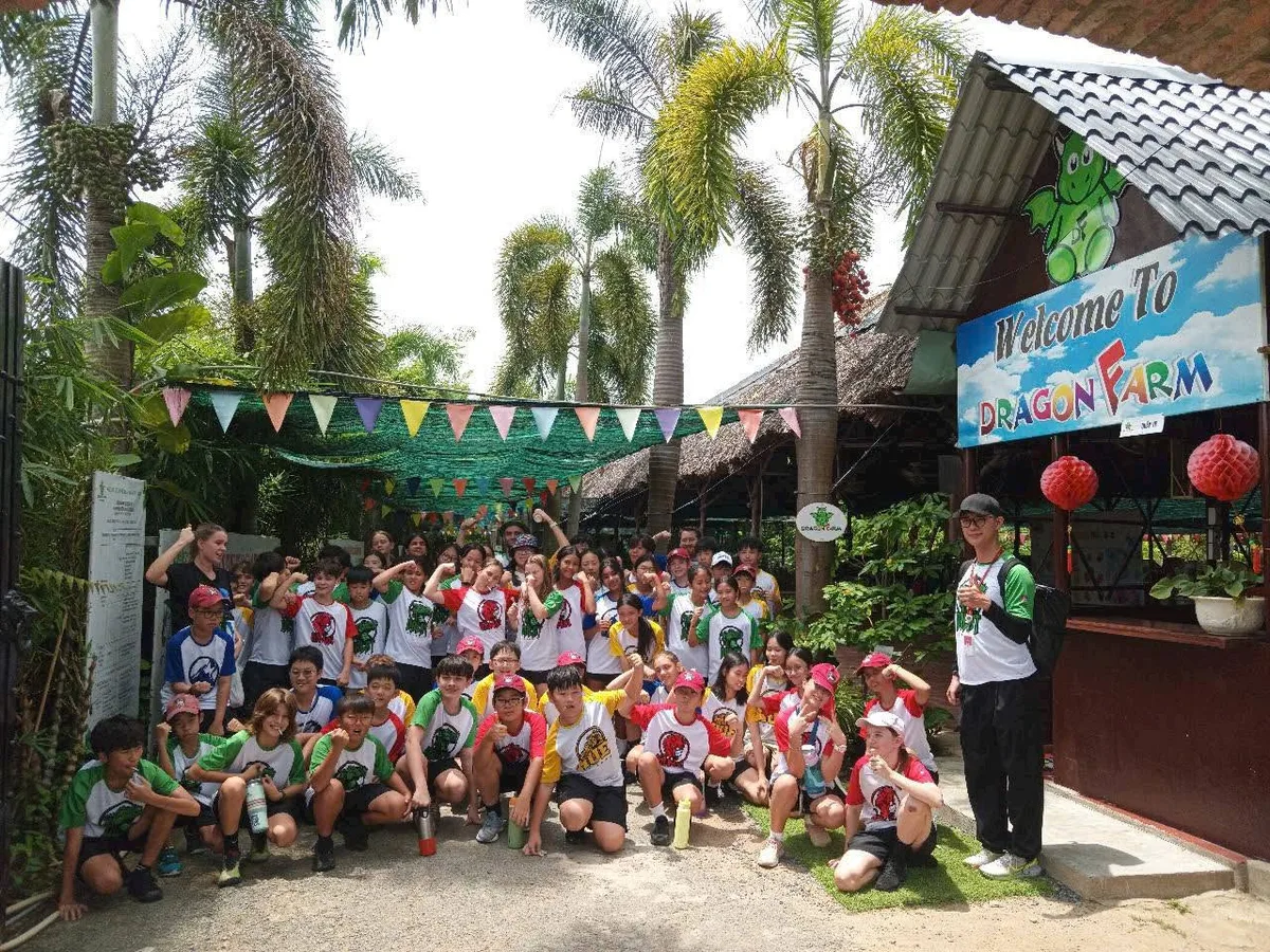 Học sinh trường quốc tế đa quốc tịch check-in trước cổng Welcome to Dragon Farm