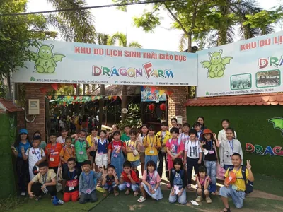 Đoàn mầm non mặc đồng phục nâu đội nón lá xinh xắn trước cổng nông trại