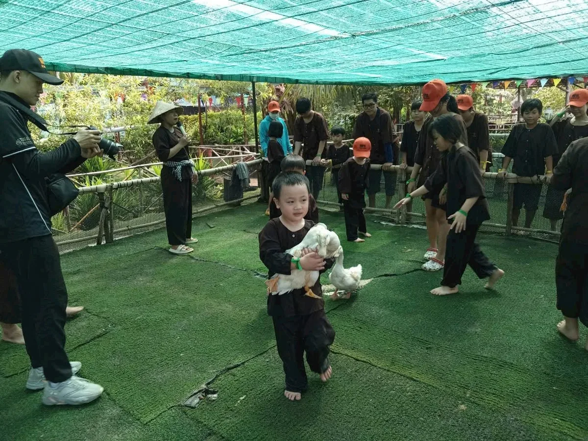 Hướng dẫn viên Dragon Farm đang hướng dẫn các bé cách bắt vịt an toàn
