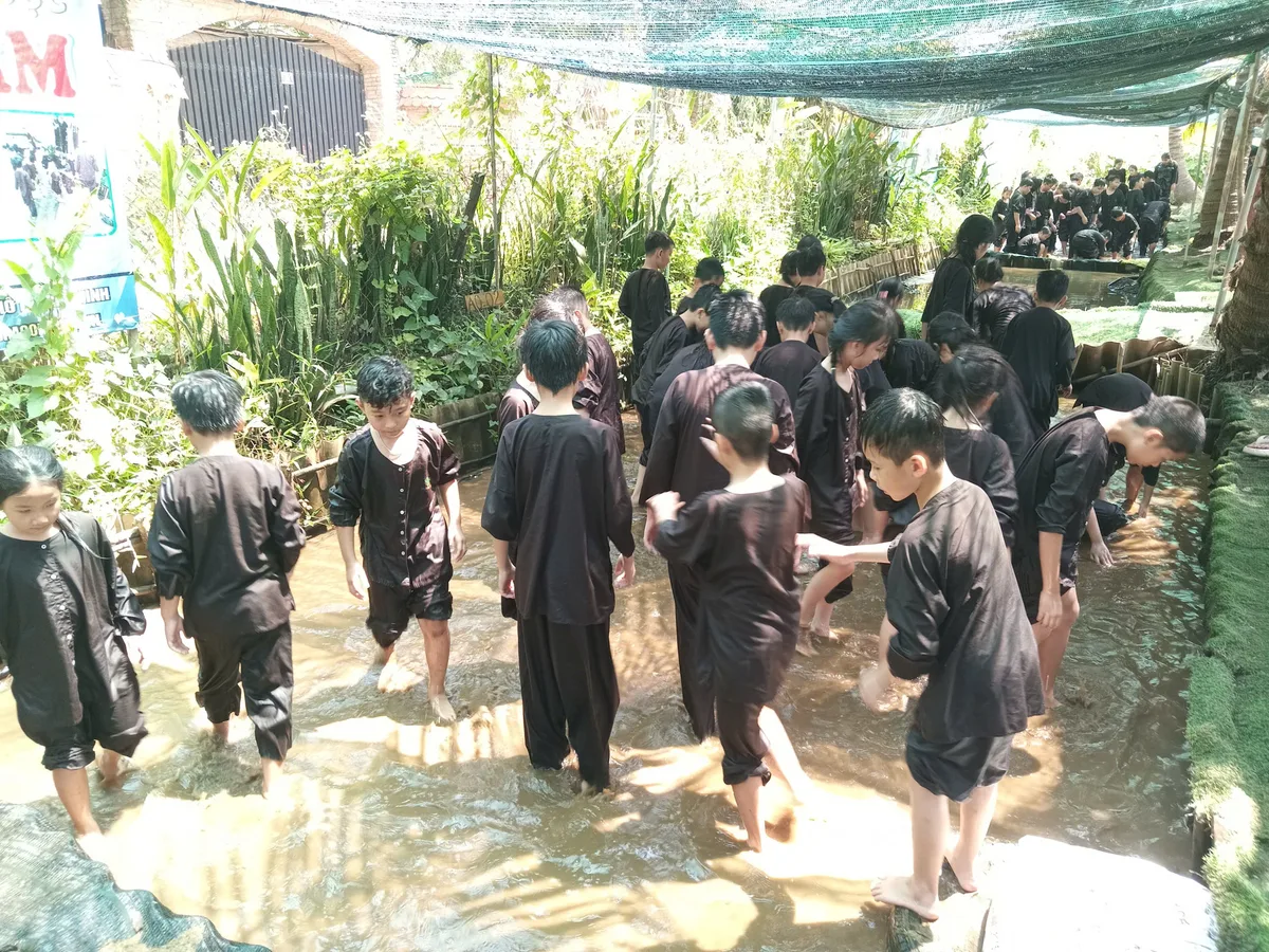 Niềm vui vỡ òa của học sinh tiểu học khi bắt được chú cá lóc béo múp dưới mương